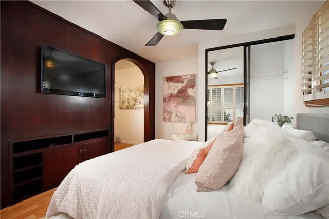 a bedroom with a large bed and a flat tv screen on dresser