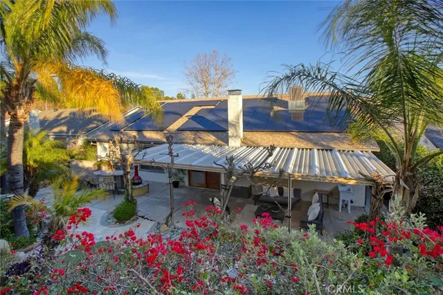 a view of a white house with a flower garden