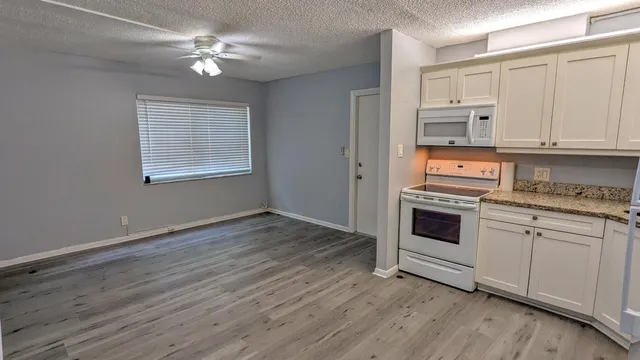 a kitchen with granite countertop a stove a sink and dishwasher with wooden floor