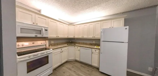 a kitchen with white cabinets and white appliances