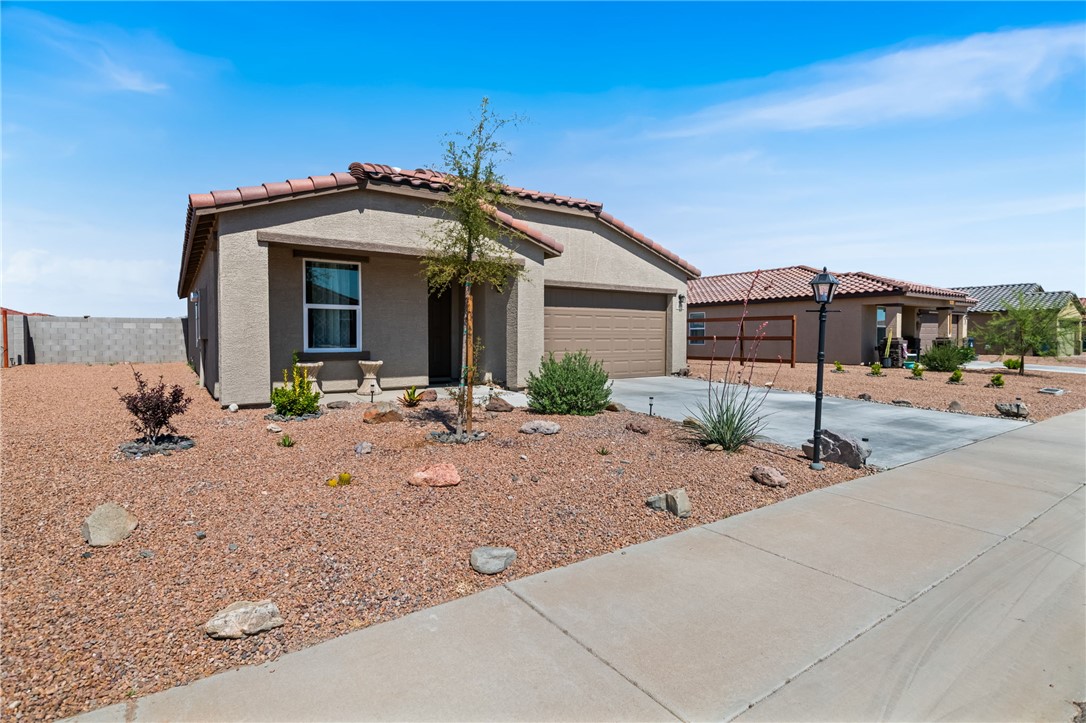 3623 East Andrea Drive Kingman, AZ 86409 - Photo 4 of 40 The property features a stucco exterior, a tiled roof, and an attached garage