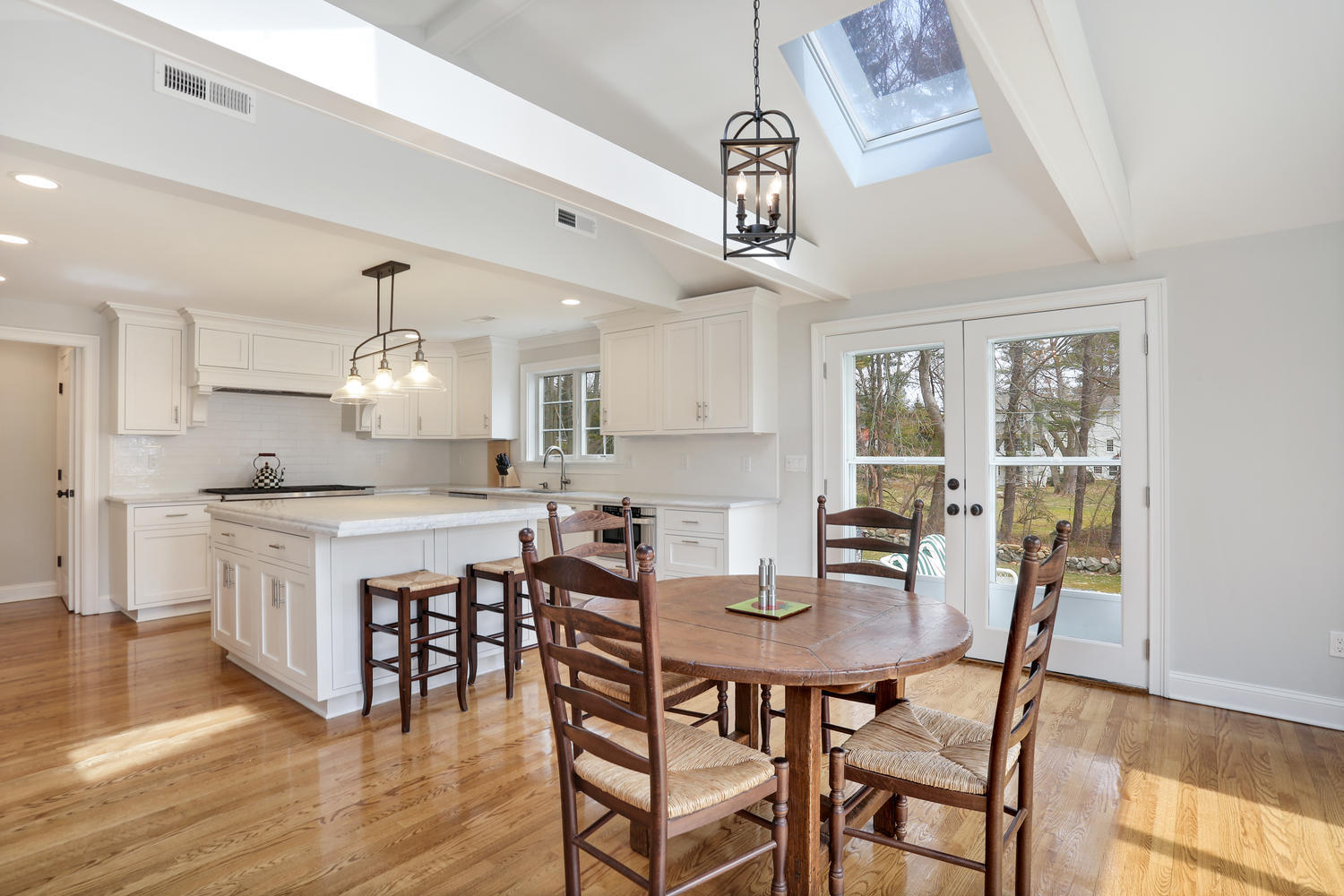 278 Davenport Ridge Road New Canaan, CT 06840 - Photo 8 of 31 a kitchen with a dining table chairs and white cabinets