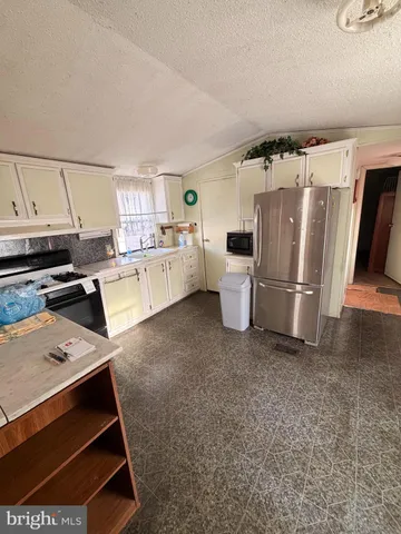 a kitchen with refrigerator and cabinets