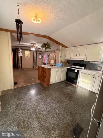 a kitchen with kitchen island granite countertop a sink stove and refrigerator