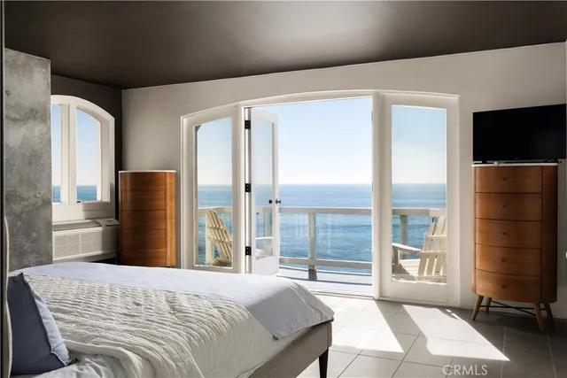 a bedroom with a bed flat screen tv and a large window