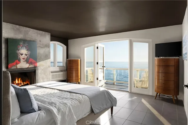 a bedroom with a large bed and a fireplace