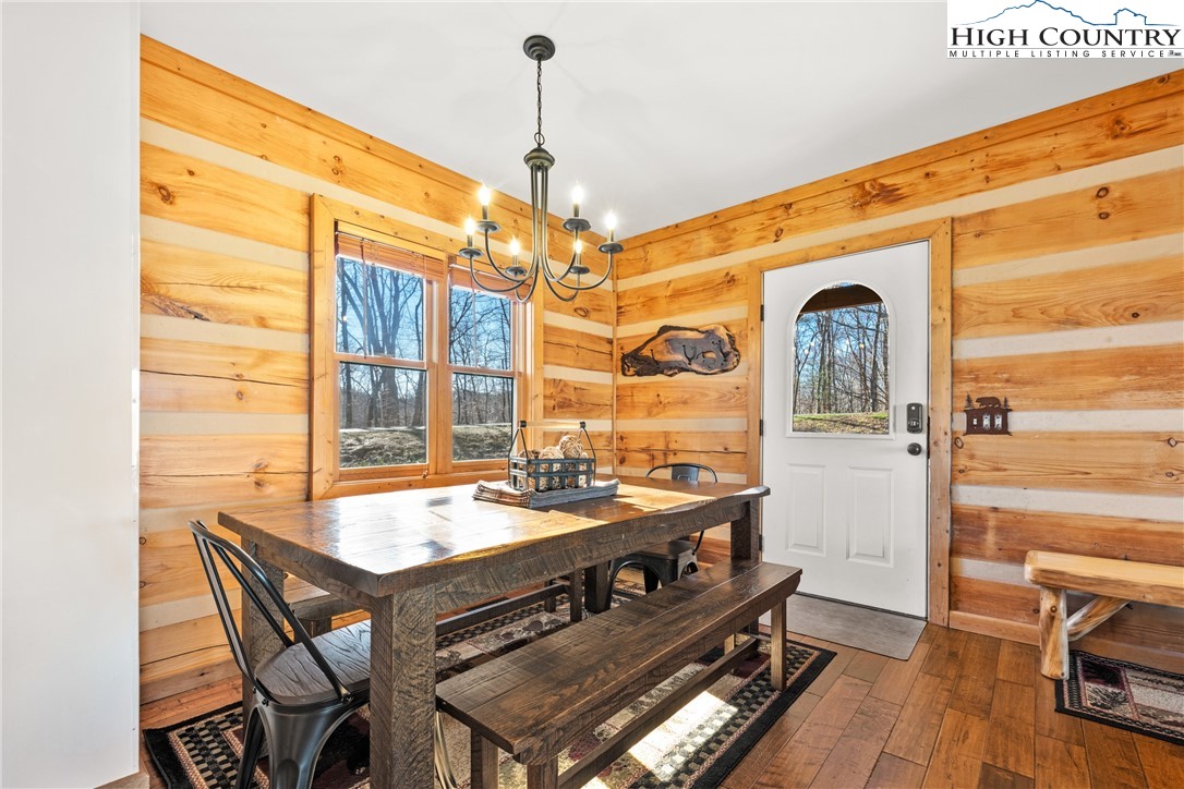 713 River Ridge Road Boone, NC 28607 - Photo 9 of 44 a dining room with wooden floor a chandelier a wooden table and chairs