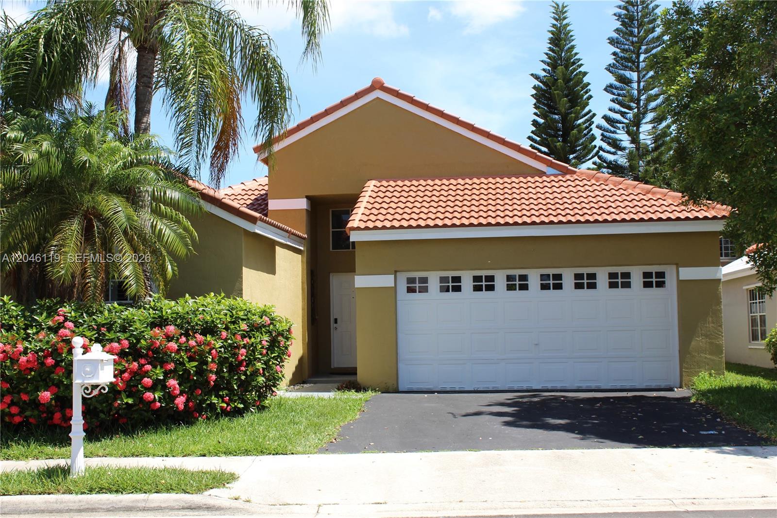 312 Bridgeton Road Weston, FL 33326 - Photo 12 of 13 a front view of a house with a garden