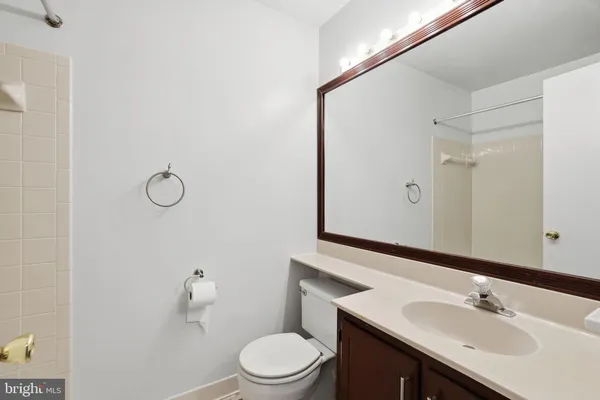 a bathroom with a sink vanity mirror and toilet
