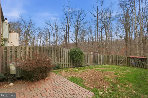 a backyard of a house with large trees and plants