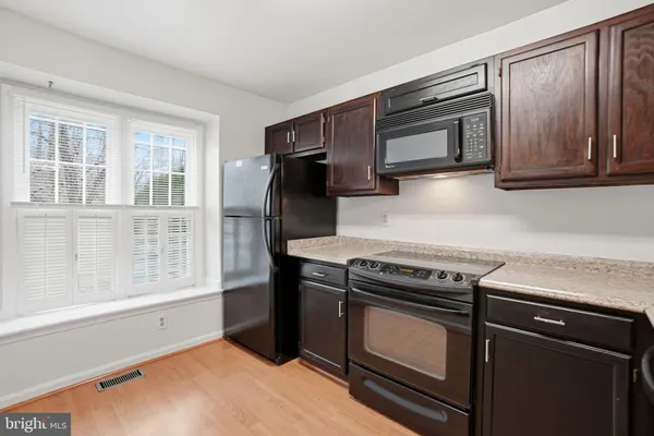 a kitchen with wooden cabinets and a stove top oven