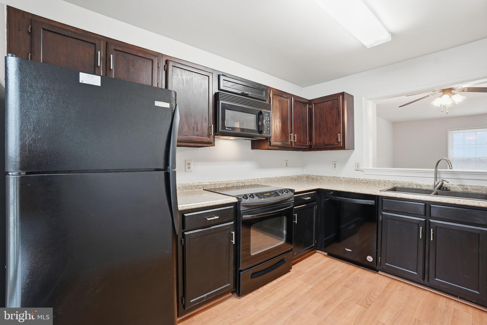 7923 Pebble Brook Court Springfield, VA 22153 - Photo 5 of 34 a kitchen with stainless steel appliances granite countertop a sink stove and refrigerator