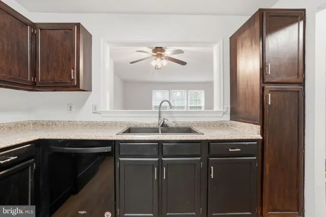 a kitchen with granite countertop a sink stainless steel appliances and cabinets