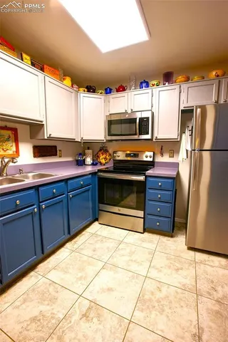 a kitchen with stainless steel appliances kitchen island granite countertop a refrigerator and a sink