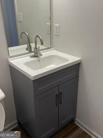 an empty room with chandelier fan and windows