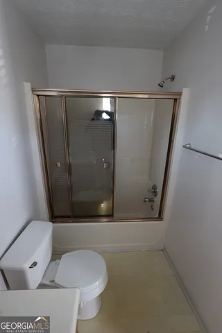 a view of an empty room and chandelier fan