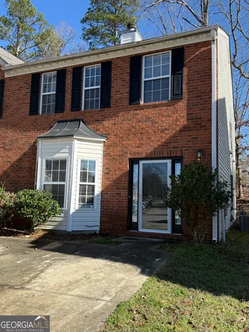 a view of a hallway with wooden floor and a bathroom