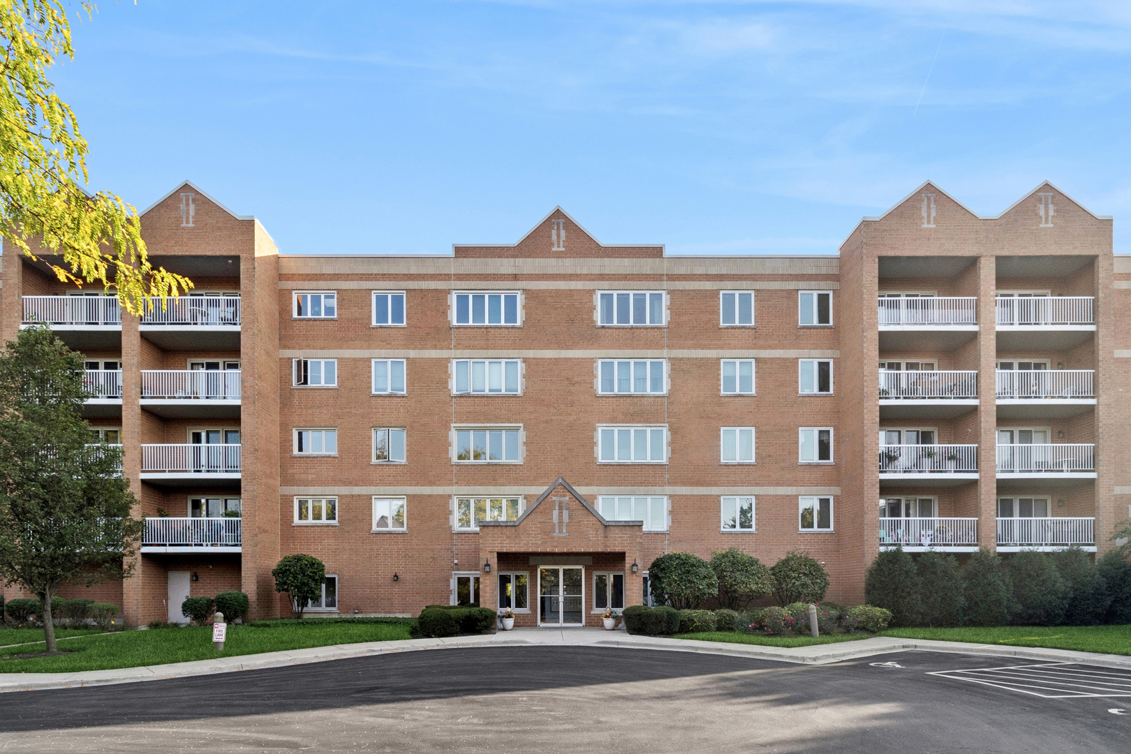 7450 North Waukegan Road, Unit 404 Niles, IL 60714 - Photo 1 of 21 a front view of a building with a yard and a garage