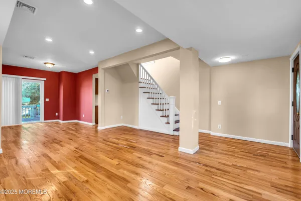 a view of empty room with wooden floor and window