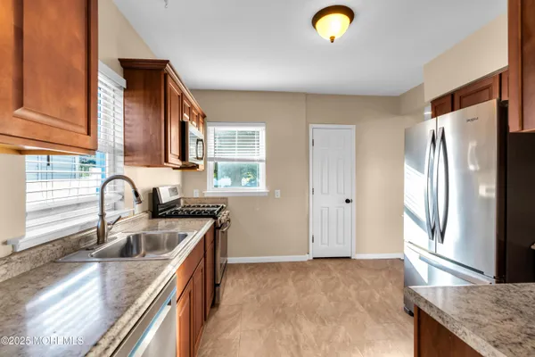 a kitchen with stainless steel appliances granite countertop a sink a stove and a refrigerator