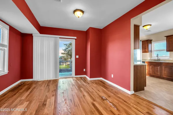 a view of a bedroom with wooden floor and windows