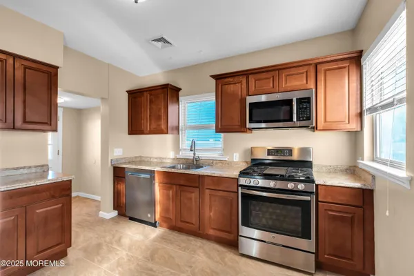 a kitchen with stainless steel appliances a stove sink microwave and cabinets
