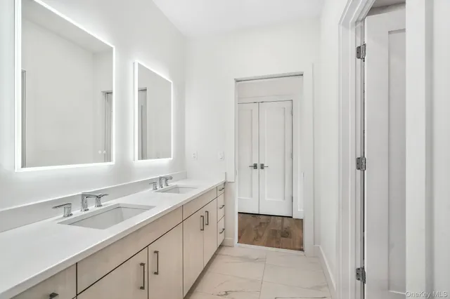 a spacious bathroom with a double vanity sink and a mirror