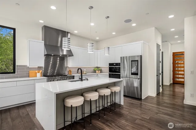 a large kitchen with stainless steel appliances lots of counter space and a sink