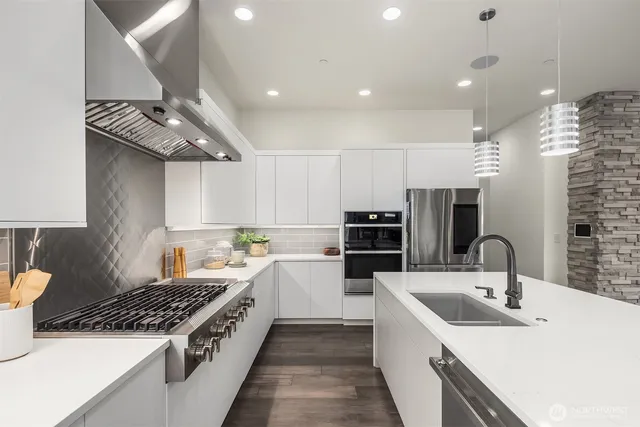 a kitchen with stainless steel appliances a sink stove and cabinets