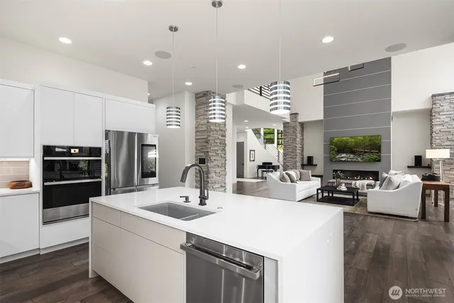 a kitchen with stainless steel appliances a sink a stove a refrigerator and cabinets