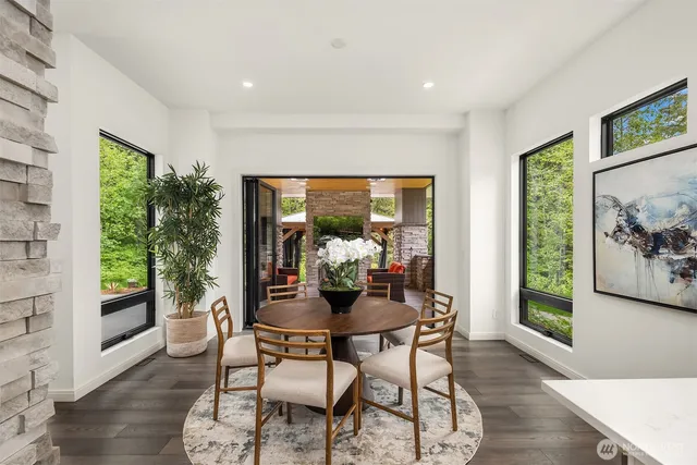 a dining room with furniture a floor to ceiling window and wooden floor