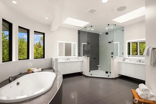 a bathroom with a tub sink shower and mirror