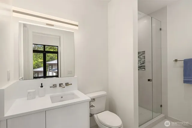 a bathroom with a sink a toilet and shower