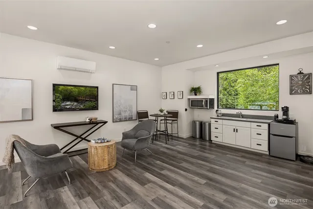 a living room with furniture a flat screen tv and a floor to ceiling window