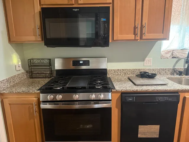 a kitchen with stainless steel appliances granite countertop a sink a cabinets and a counter space