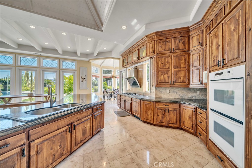 43744 Calle De Velardo Temecula, CA 92592 - Photo 12 of 60 a large kitchen with stainless steel appliances granite countertop a large stove a sink and a microwave