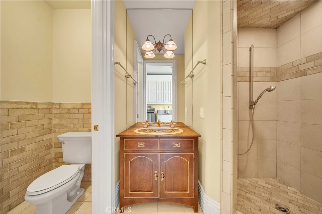 43744 Calle De Velardo Temecula, CA 92592 - Photo 39 of 60 a bathroom with a granite countertop toilet a sink and a shower