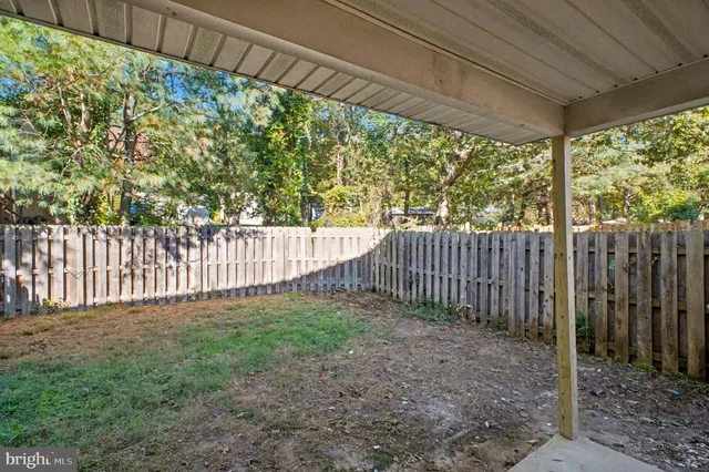a view of a yard with wooden fence