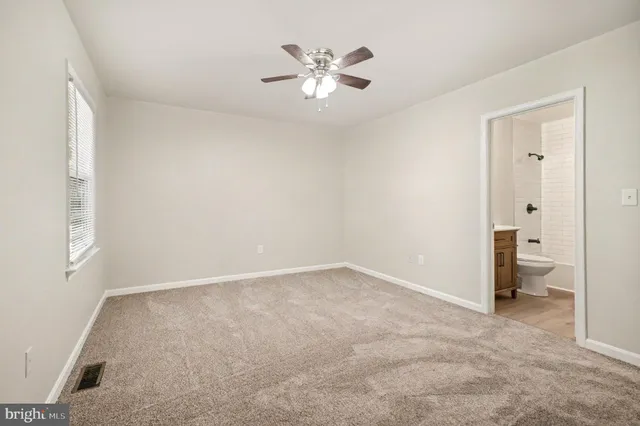 an empty room with closet and a ceiling fan