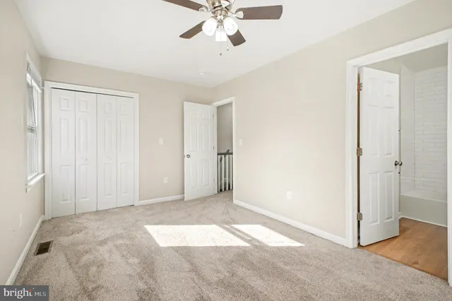 a view of a livingroom with a ceiling fan & entryway