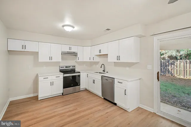 a kitchen with granite countertop white cabinets and white appliances