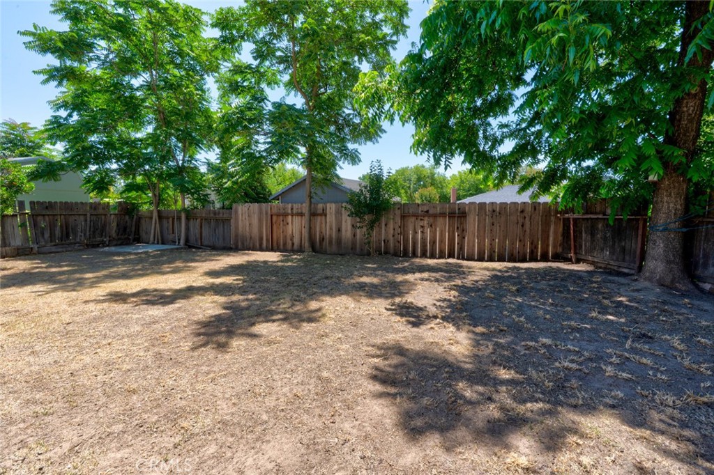 1840 Cheyenne Drive Merced, CA 95348 - Photo 73 of 90 a view of a backyard with large tree and wooden fence