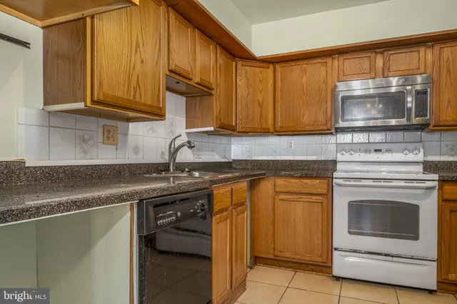 a kitchen with stainless steel appliances granite countertop a sink stove and microwave