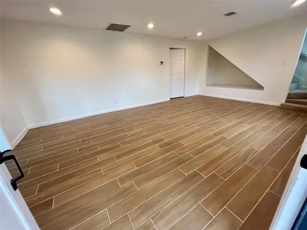 a view of empty room with wooden floor