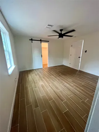 en empty room with wooden floor and windows