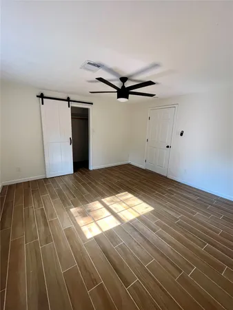 a view of empty room with wooden floor