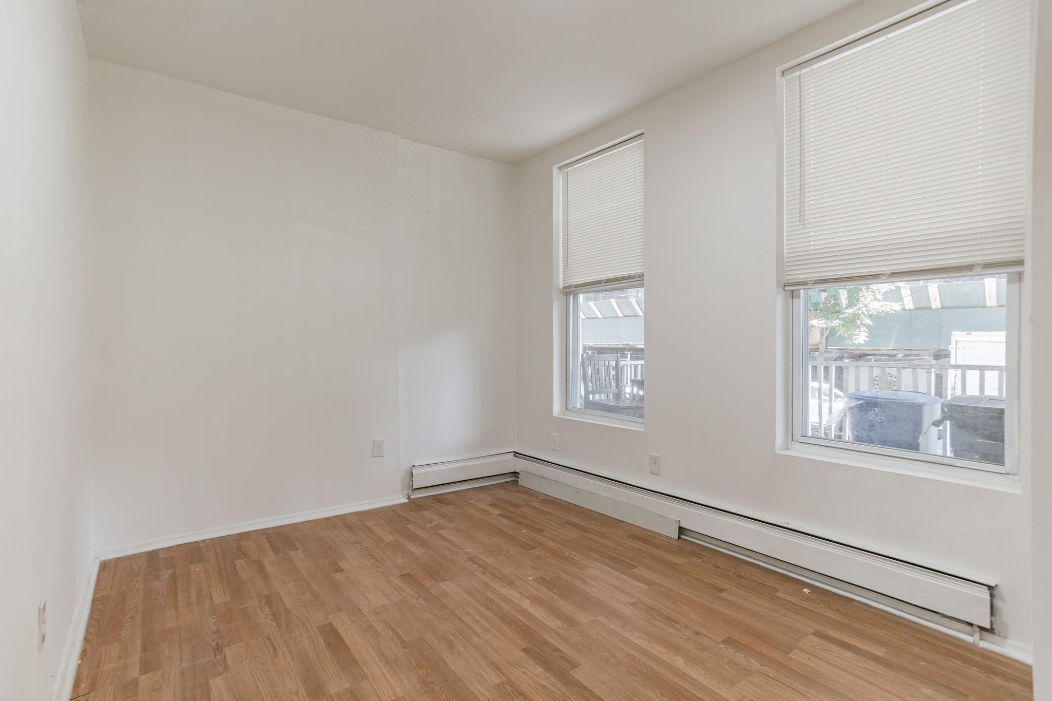 2263 Ryer Avenue Bronx, NY 10457 - Photo 12 of 49 Empty room with baseboard heating and light wood-type flooring