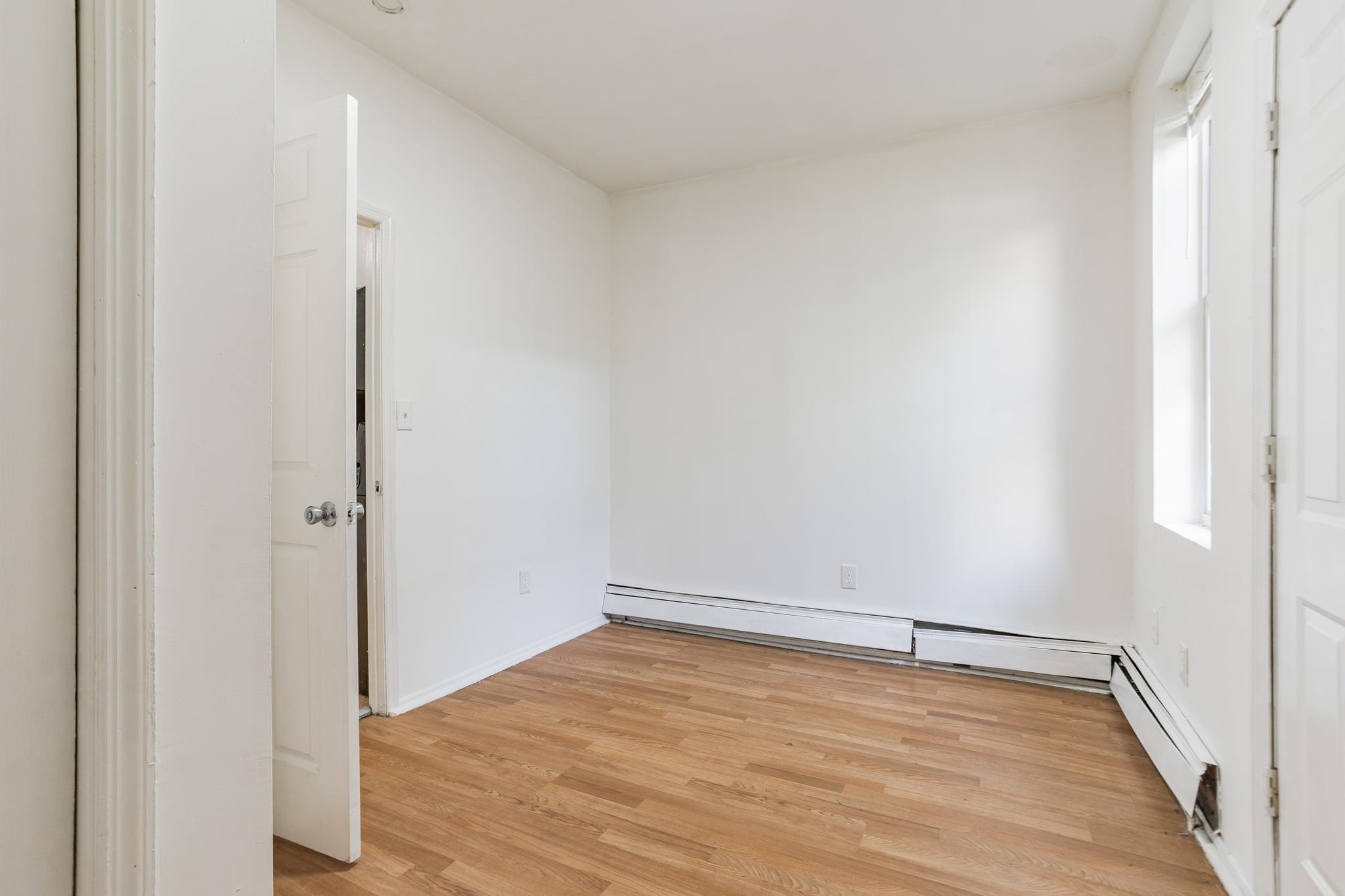 2263 Ryer Avenue Bronx, NY 10457 - Photo 18 of 49 Spare room with light wood-style flooring and baseboards