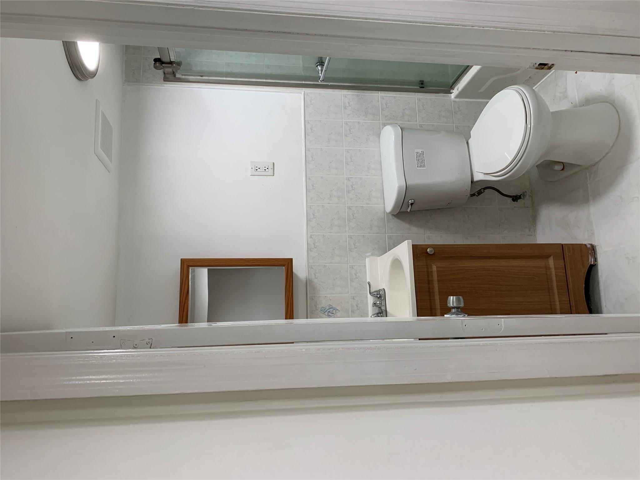 2263 Ryer Avenue Bronx, NY 10457 - Photo 30 of 49 Full bath with vanity, tile walls, toilet, marble finish floor, and combined bath / shower with glass door