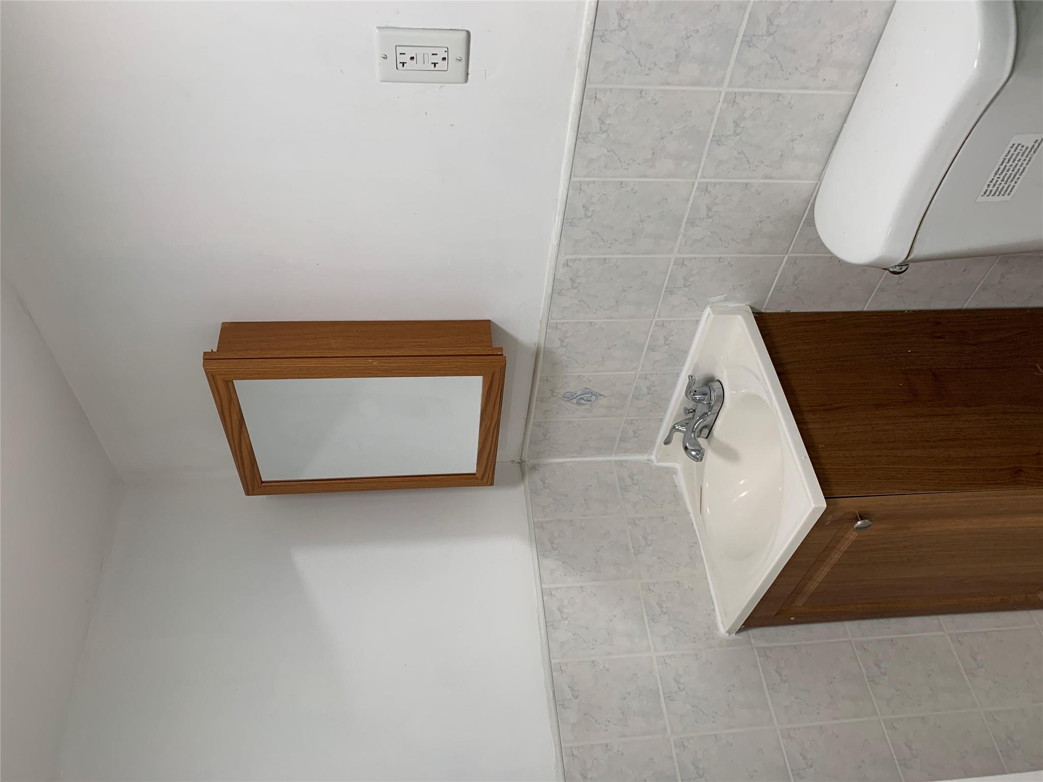 2263 Ryer Avenue Bronx, NY 10457 - Photo 33 of 49 Bathroom featuring toilet, vanity, a wainscoted wall, and tile walls